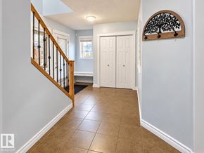 Edmonton apartment for rent - A hallway with a tiled floor and a wooden staircase.