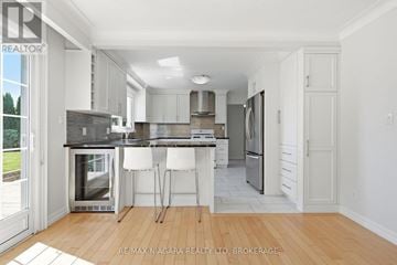 St. Catharines (Martindale Pond) apartment for rent - A modern kitchen with white cabinets and a wooden floor.