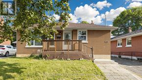 Oshawa (Donevan) apartment for rent - A small brick house with a porch and a car parked in front.
