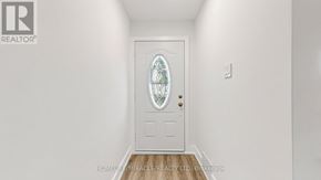 Oshawa (Donevan) apartment for rent - A white door with a glass window in the middle is set in a white wall.