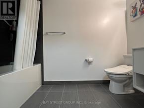 Toronto (Cabbagetown-South St. James Town) condo for rent - A white toilet in a bathroom with a white bathtub and a white wall.