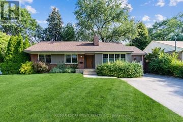 Mississauga (Lakeview) apartment for rent - A house with a brown roof and a brick chimney is surrounded by greenery.