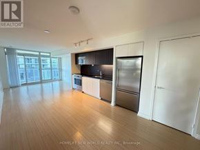 Toronto (Waterfront Communities) condo for rent - A spacious kitchen with wooden floors and stainless steel appliances.
