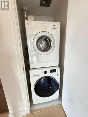 Toronto (Waterfront Communities) condo for rent - A white washing machine and dryer in a small laundry room.