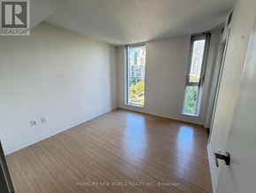 Toronto (Waterfront Communities) condo for rent - A room with wooden flooring and a sliding glass door leading to a balcony.