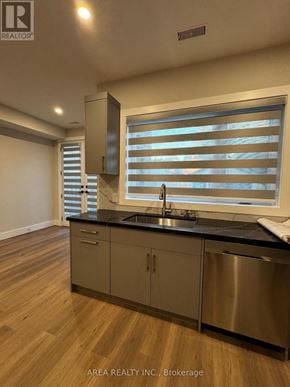 Toronto (Oakwood Village) triplex for rent - A kitchen with wooden floors and a stainless steel sink.