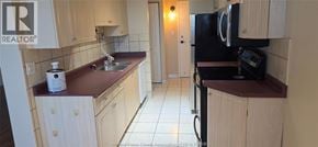 Windsor condo for rent - A kitchen with a sink, refrigerator, and cabinets.