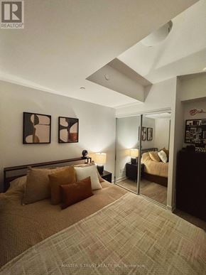 Toronto (Waterfront Communities) condo for rent - A bedroom with a bed, nightstands, and a mirror.