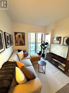 Toronto (Waterfront Communities) condo for rent - A living room with a couch, a television, and a window.