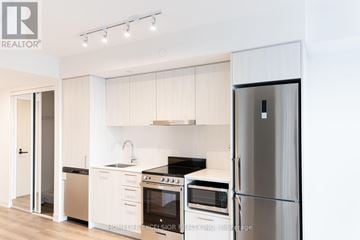 Vaughan (Vaughan Corporate Centre) condo for rent - A modern kitchen with white cabinets and stainless steel appliances.
