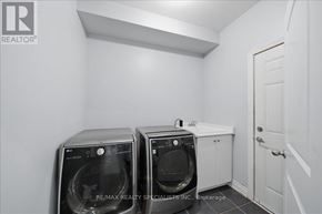 Bradford West Gwillimbury (Bradford) apartment for rent - A laundry room with two washing machines and a door.