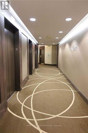 Toronto (Bay Street Corridor) condo for rent - A hallway with a carpeted floor and a series of doors on the left side.