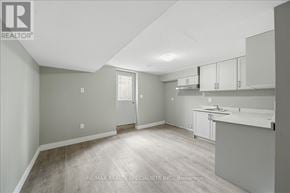 Bradford West Gwillimbury (Bradford) apartment for rent - A spacious kitchen and living room with white cabinetry and a wood floor.