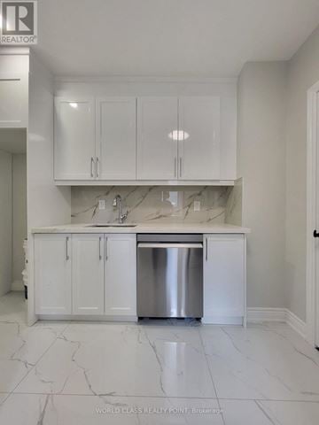 Toronto (Junction Area) duplex for rent - A white kitchen with a marble floor and a stainless steel dishwasher.