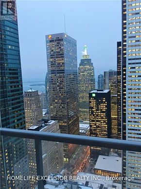 Toronto (Bay Street Corridor) condo for rent - A cityscape with skyscrapers and a sign that reads "HOMELIFE EXCELSIOR REALTY INC., Brokerage".