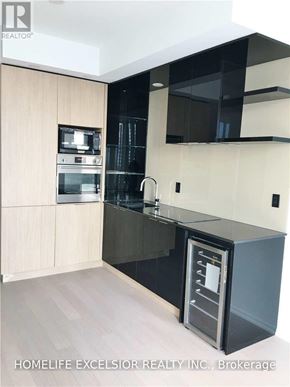 Toronto (Bay Street Corridor) condo for rent - A modern kitchen with a sink and a refrigerator.