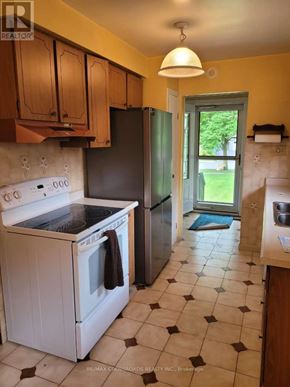 Richmond Hill (Crosby) apartment for rent - A kitchen with a white stove top oven and a black refrigerator.