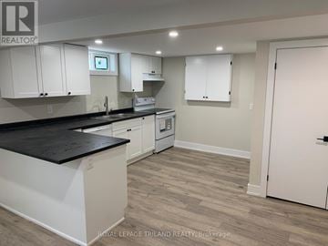 London East (East I) duplex for rent - A kitchen with white cabinets and a black countertop.