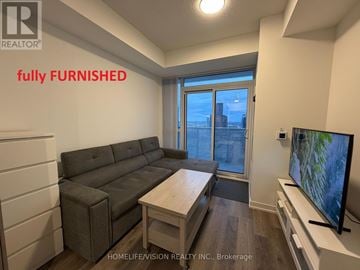 Vaughan (Vaughan Corporate Centre) condo for rent - A living room with a grey couch and a flat screen TV.