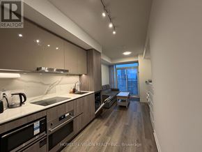 Vaughan (Vaughan Corporate Centre) condo for rent - A modern kitchen with dark wood floors and stainless steel appliances.