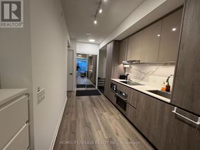 Vaughan (Vaughan Corporate Centre) condo for rent - A modern kitchen with wooden cabinets and a marble countertop.