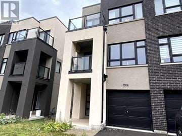 Burlington (Alton) townhouse for rent - A modern apartment building with balconies and garage doors.