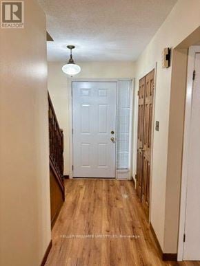 London East (East H) townhouse for rent - A hallway with a white door and wooden floors.