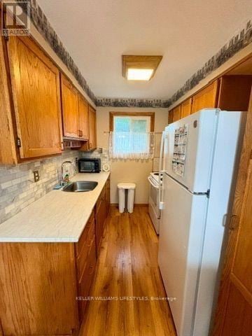 London East (East H) townhouse for rent - A kitchen with wooden cabinets and a white fridge.