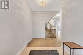 Ottawa apartment for rent - A hallway with a wooden floor and a metal staircase.