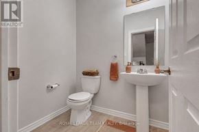 Ottawa apartment for rent - A white toilet sits next to a white pedestal sink in a bathroom.