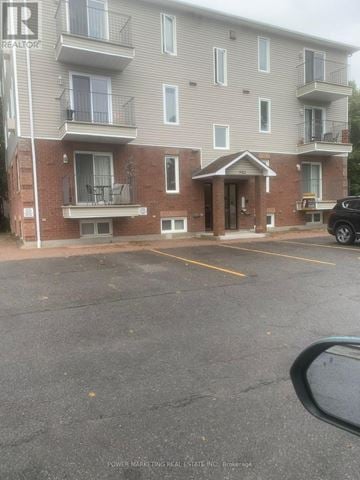 Russell condo for rent - A building with a parking lot in front of it.