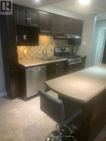 Russell condo for rent - A kitchen with dark brown cabinets and a tile backsplash.
