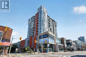 Ottawa condo for rent - A modern multi-story building with glass windows and a sign that reads "REALTOR" is situated at an intersection with traffic lights and pedestrian crossings.