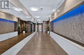 Ottawa condo for rent - A long hallway with a plant on each side and a logo on the wall.