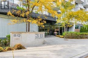 Toronto (Kensington-Chinatown) condo for rent - The image shows a building entrance with a sign that reads "SQ 38 Cameron" and a yellow tree in front.