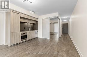 Toronto (Kensington-Chinatown) condo for rent - A spacious kitchen with wooden cabinets and a white countertop.