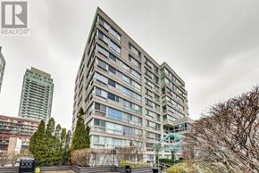 Toronto (Mount Pleasant West) townhouse for rent - A tall building with many windows is the main focus of this image.