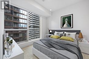 Toronto (Waterfront Communities) condo for rent - A bedroom with a large bed and a painting of a white horse on the wall.
