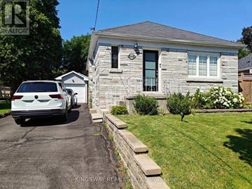 Oshawa (Centennial) apartment for rent - A white car is parked in front of a house with a sign that says "REALTOR".