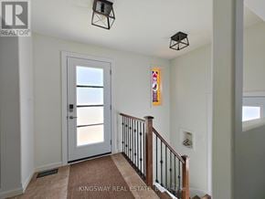 Oshawa (Centennial) apartment for rent - A hallway with a white door and a staircase with a black railing.