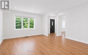 Oshawa (Centennial) apartment for rent - A room with wooden flooring and a large window with trees visible outside.