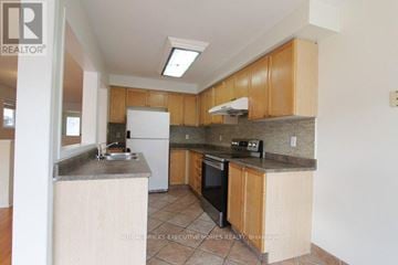 Mississauga (Lisgar) apartment for rent - A kitchen with wooden cabinets and a white fridge.