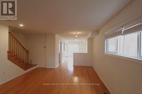 Mississauga (Lisgar) apartment for rent - A spacious room with wooden floors and white walls.