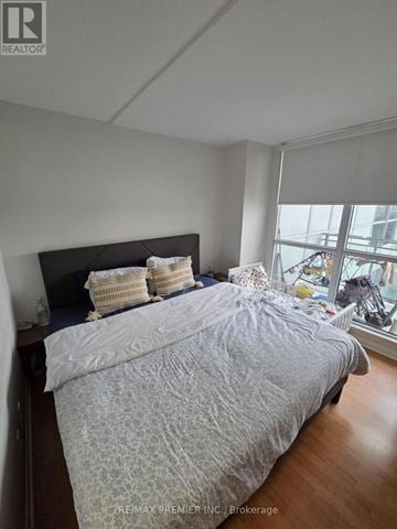 Toronto (Keelesdale-Eglinton West) condo for rent - A bedroom with a large bed and a window overlooking a city.