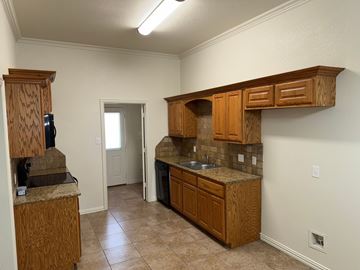 Temple triplex for rent - A kitchen with wooden cabinets and a granite countertop.