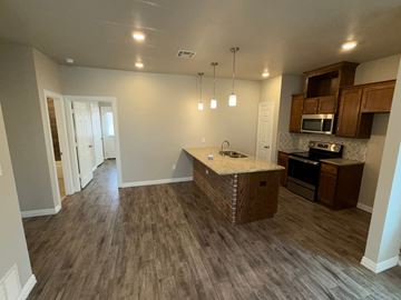 Temple townhouse for rent - A kitchen with a granite counter top and wooden cabinets.