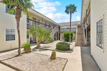 Slidell apartment for rent - A courtyard with a gravel area and a few plants and trees.
