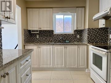 Markham (Markville) apartment for rent - A kitchen with white cabinets and a black and white checkered backsplash.