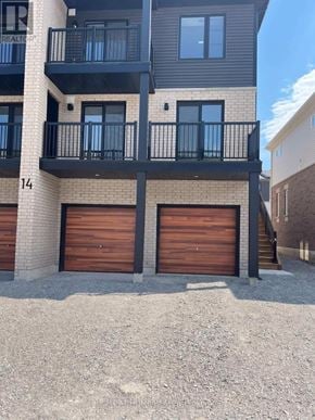 Barrie townhouse for rent - A building with the number 14 on it has two garage doors.