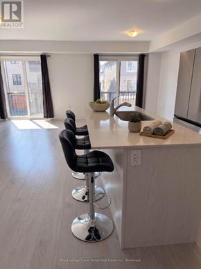 Barrie townhouse for rent - A kitchen with a bar area and chairs.